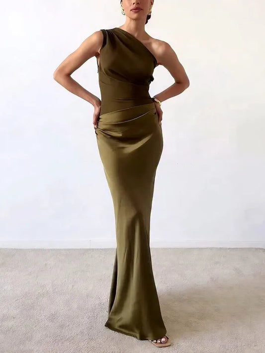 Woman wearing a long, one-shoulder olive green dress against a white background