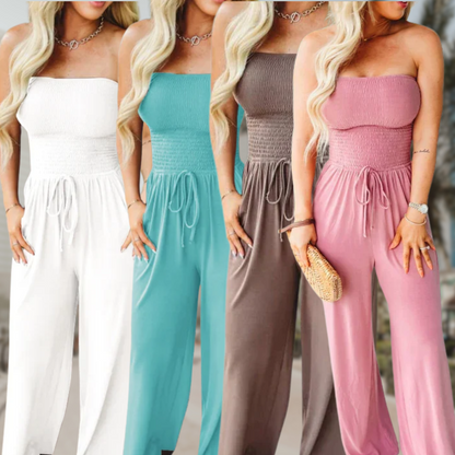 Four women wearing strapless jumpsuits in white, teal, brown, and pink.