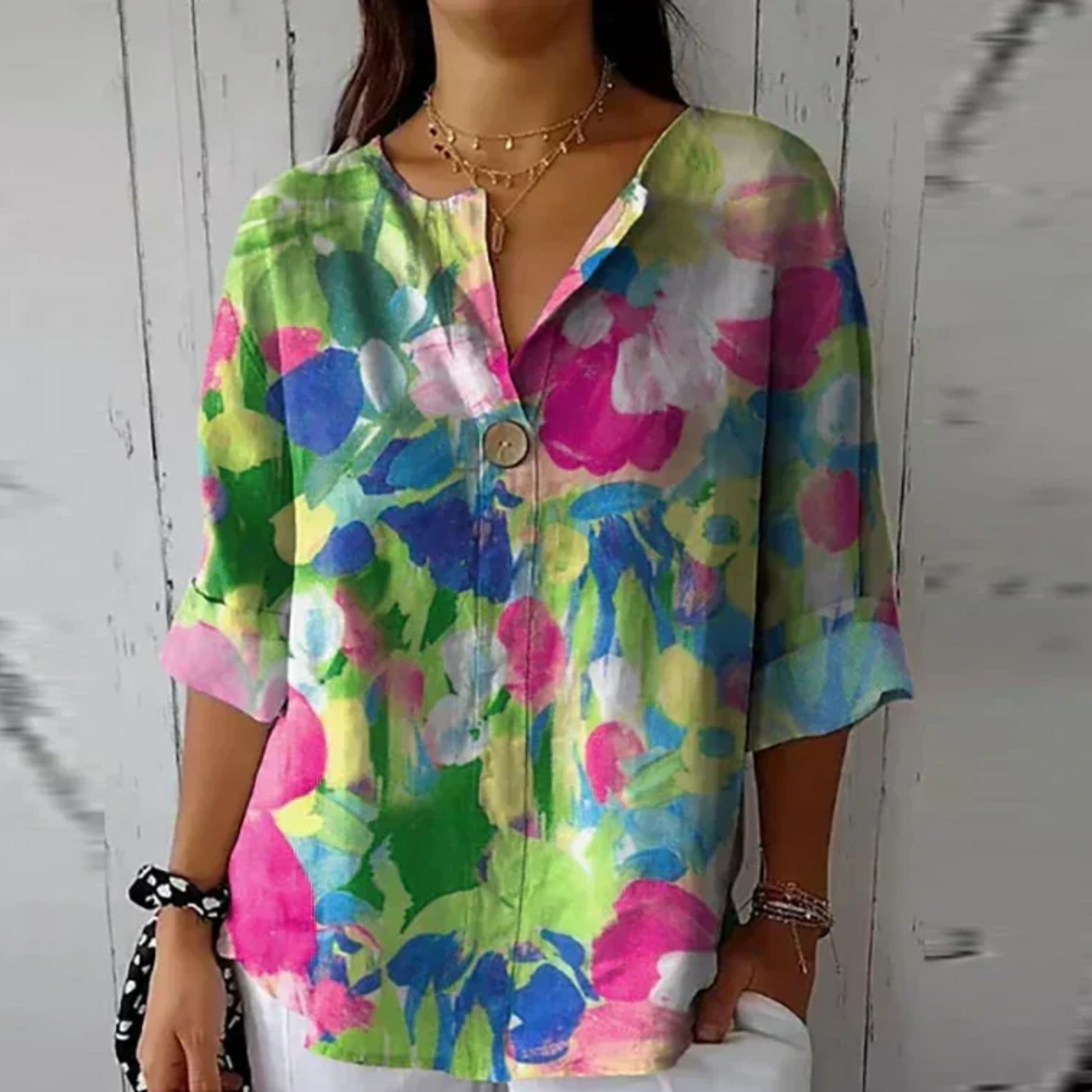 Person wearing a colorful floral shirt against a wooden background