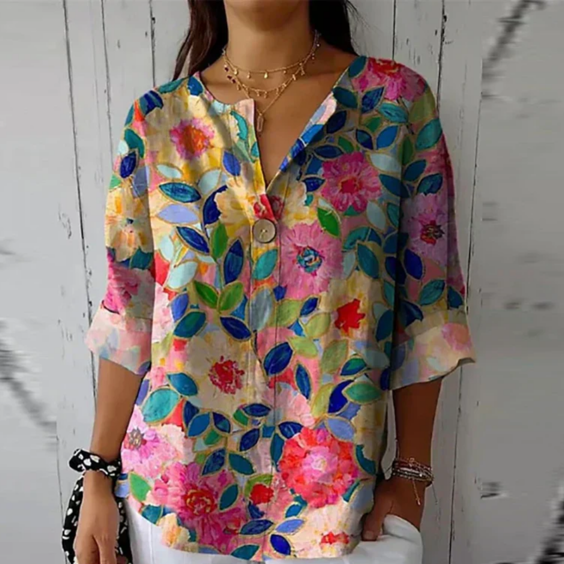 Colorful floral shirt worn by a person against a white wooden background