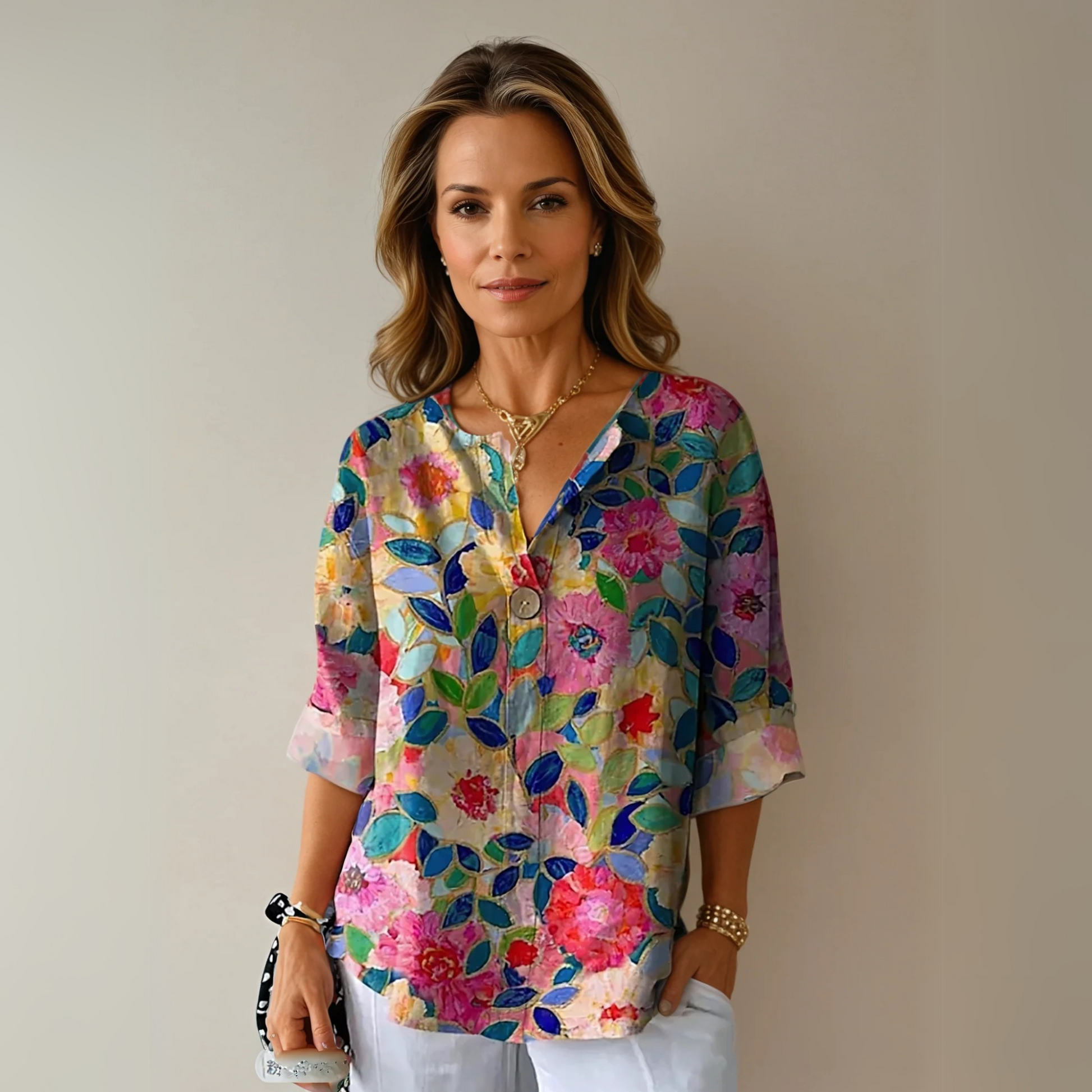 Woman wearing a colorful floral blouse against a plain background