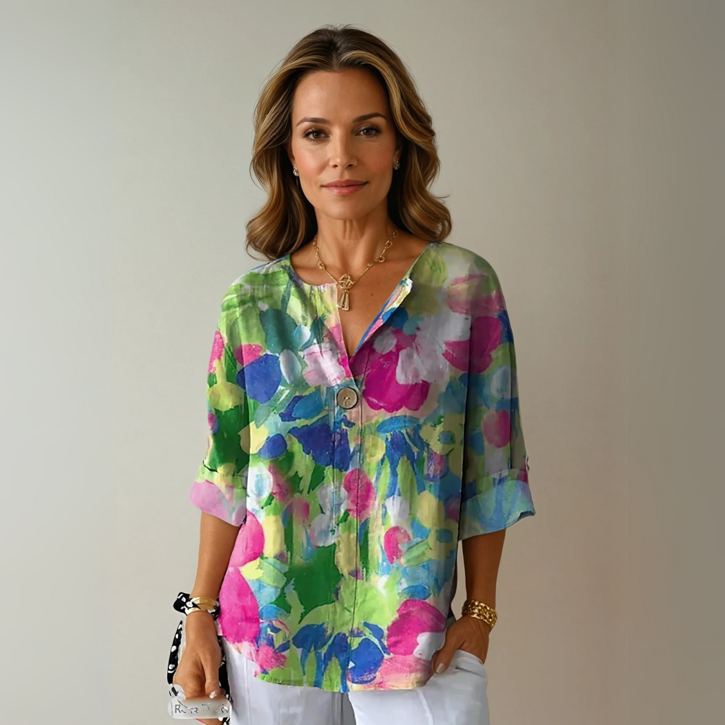 Woman wearing a colorful floral blouse against a plain background